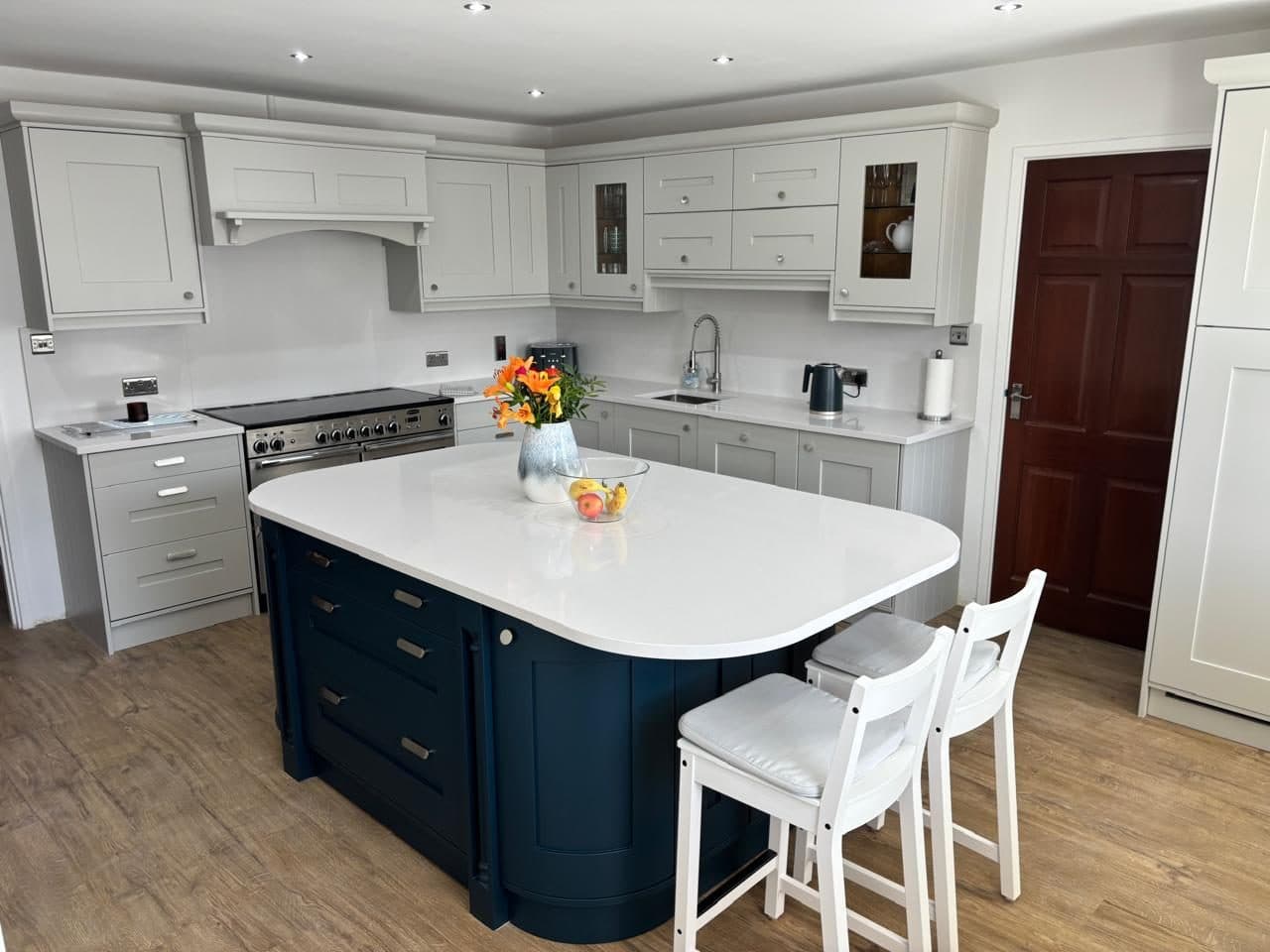 After: the same kitchen resprayed soft grey with a navy island